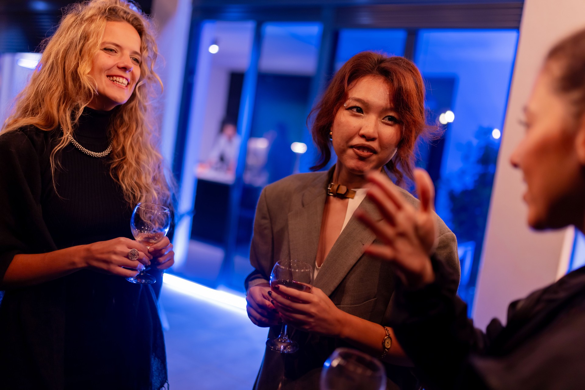 Group of people enjoying a lively conversation at a modern evening gathering